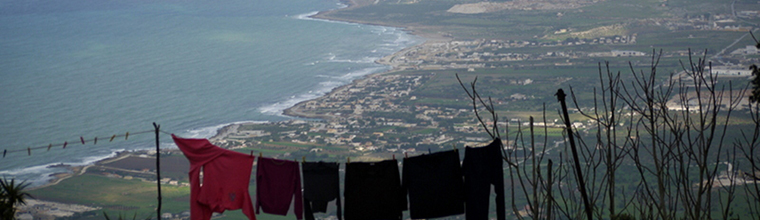 The laundry room with a view.  Conquered in 831 Erice, a  hilltop town (731m/2398 ft in elevation) was an Elymian city (the Elymians were around before the Greeks ever set foot in Sicily), originally named Eryx.  It was ruled by Arabs for 300 years, then taken by the Normans in 1167.  The town maintains a medieval look and feel with narrow cobblestoned streets lined with stone buildings.  The  contrasting and conflicting elements of modern day laundry hanging on a line to dry with a vista of the western coastline of Sicily in a historical town was hilarious to me.  It was a partly cloudy, windy and cold day with scattered rain showers when I photographed this image with my Panasonic DMC-GF1 camera.  Erice, Sicily, Italia.  January 27, 2013. - Laurel Pfund